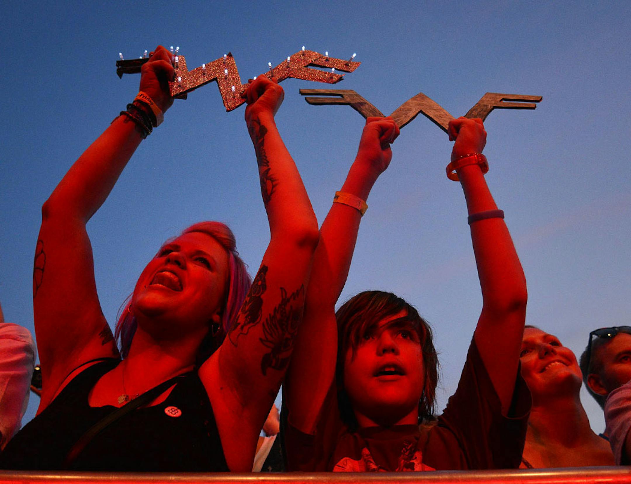 Center from left, Betsy Nielsen and Dexter Pardick, 11, both of Granite Falls, held up their "W" signs while Weezer performed in Minneapolis, Minn., during The Basilica Block Party on Friday July 10, 2015. The Block Party features food vendors and performers such as Weezer and Wilco. The Block Party�s proceeds benefit the Basilica Landmark and The Basilica�s St. Vincent de Paul outreach program.