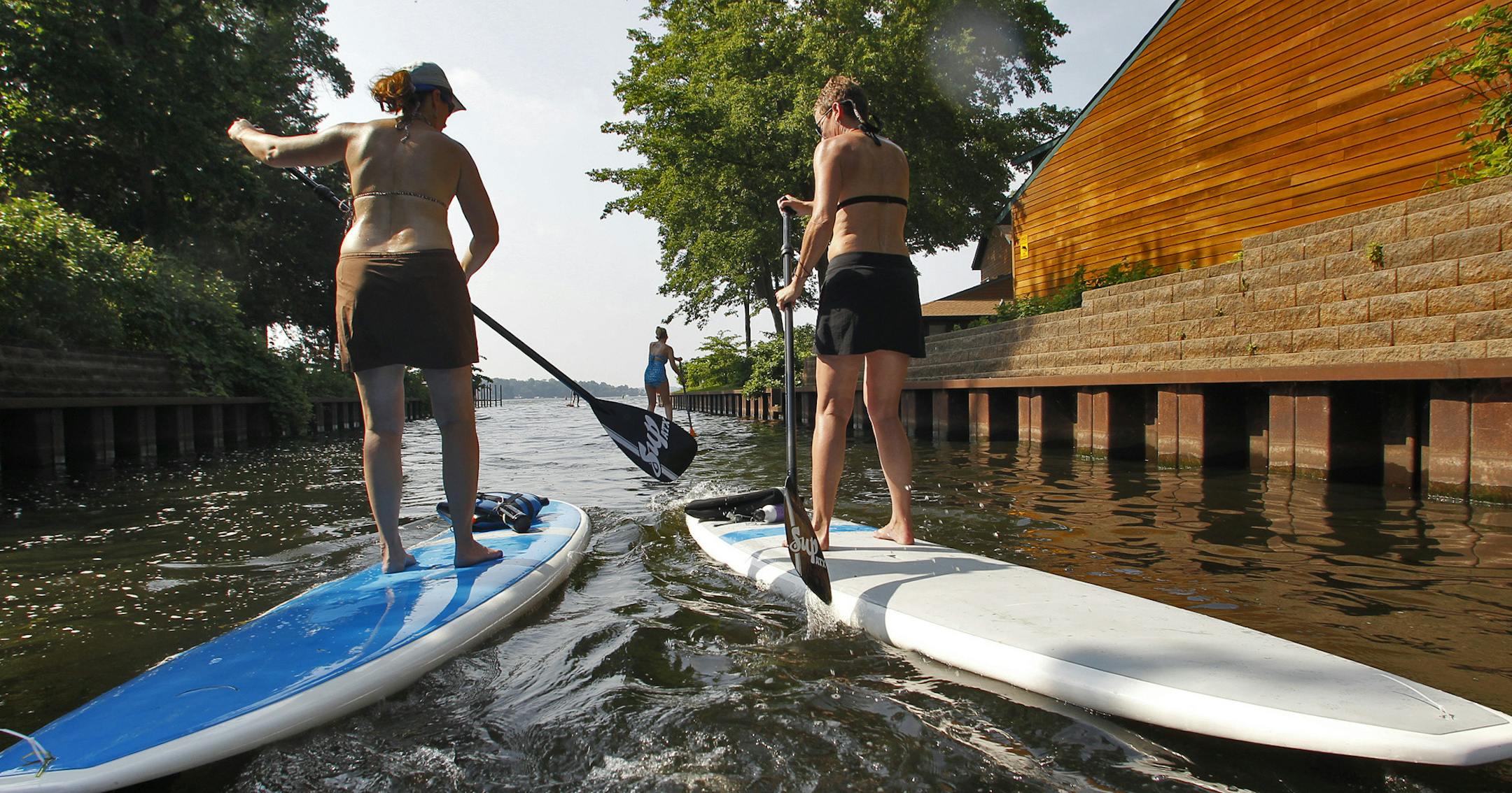 Stand-up paddleboarding involves standing on a 9-foot board while paddling quiet lake or pond waters. It is becoming increasingly popular in Minnesota. A group headed out on Lake Minnetonka in Mound on Sunday July 17, 2011. ](MARLIN LEVISON/STARTRIBUNE ) mlevison@startribune.combestmn2012 bestmn2012