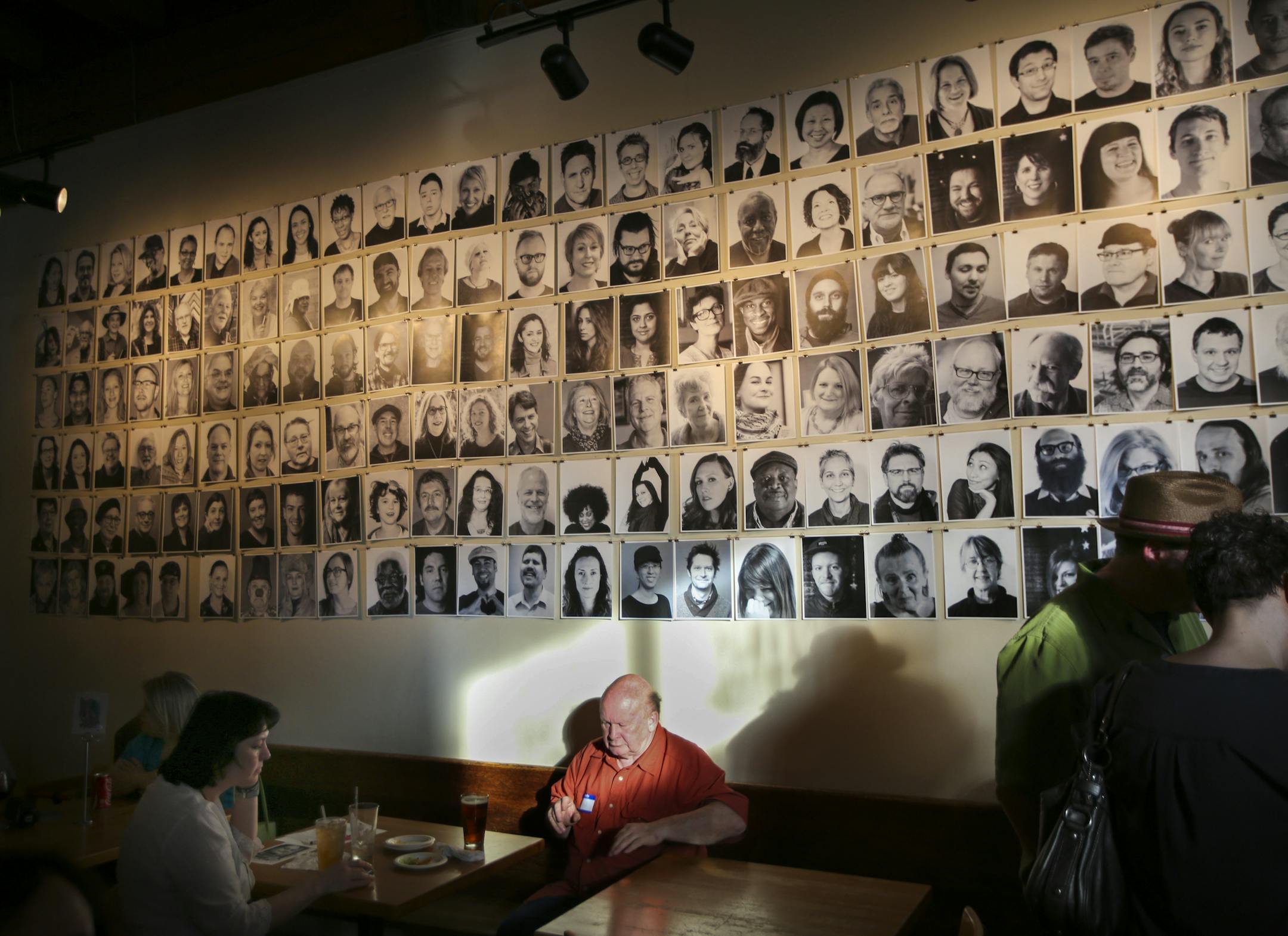 Small versions of the 180 portrait photographs, that are displayed on buildings in the Lowertown neighborhood, hung on display during a public celebration of the Inside Out project at the Black Dog Wine and Coffee Bar of St. Paul, Minn. on Thursday, May 28, 2015. ] RENEE JONES SCHNEIDER ï reneejones@startribune.com The big, black-and-white head shorts are part of an international participatory art project founded by a French artist who goes by the moniker JR. Nearly 200,000 people from more