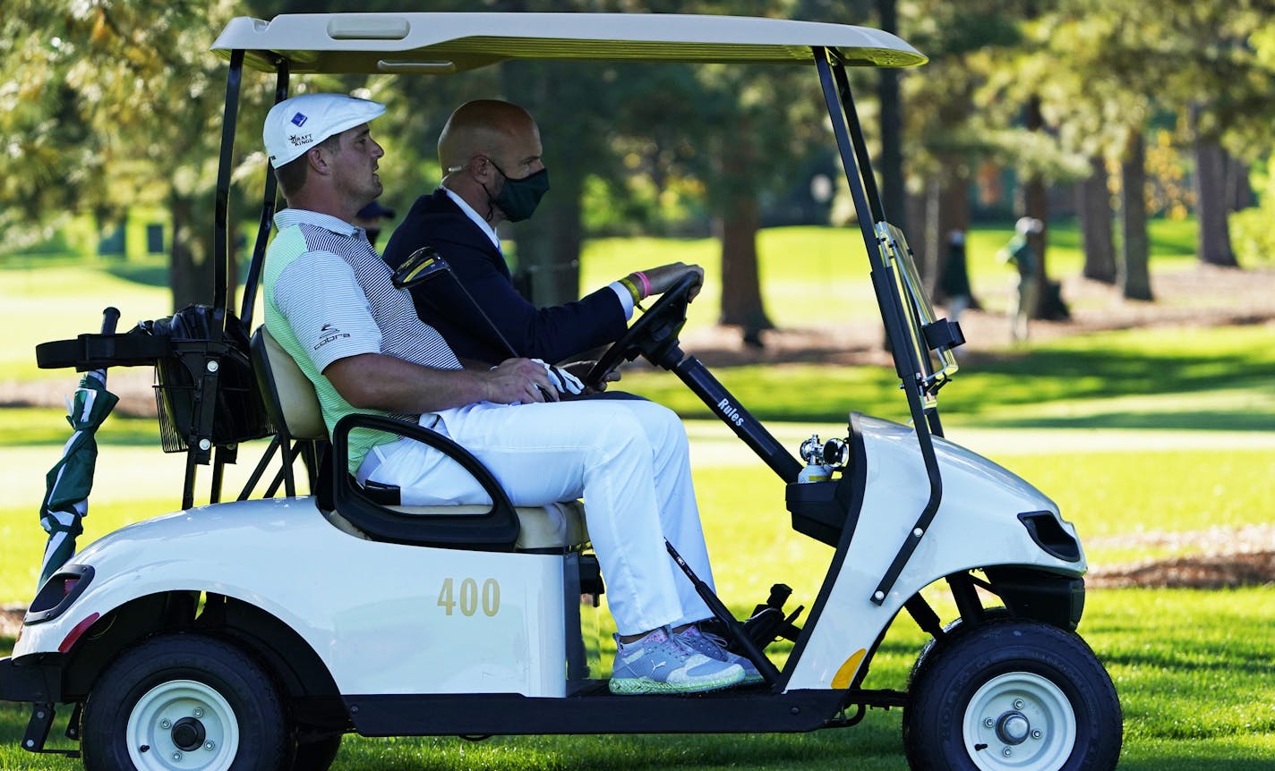 Bryson DeChambeau gets a ride back to the third tee box to hit again after his ball was lost during the second round of the Masters golf tournament Friday, Nov. 13, 2020, in Augusta, Ga. (AP Photo/David J. Phillip)