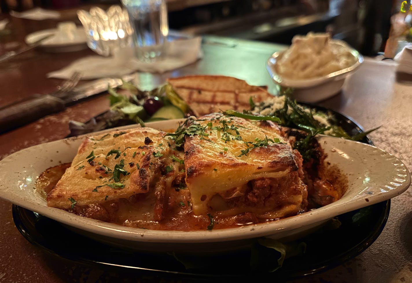 A shallow white baking dish holds layers of cheese and pasta on the well-worn bar inside Phil's Tara Hideaway.