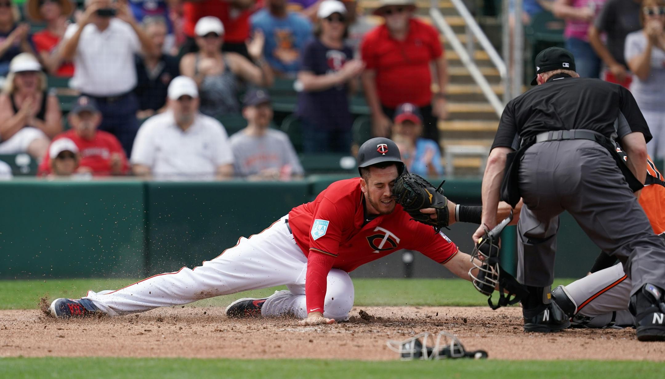Minnesota Twins first baseman C.J. Cron (24) was tagged out at home by Baltimore Orioles catcher Austin Wynns (61) during Monday's game.