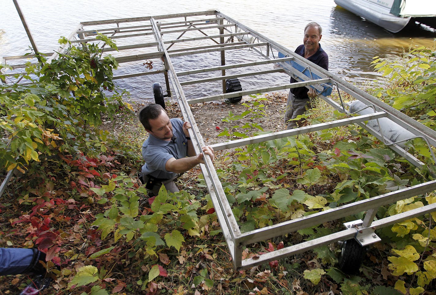 DNR Invasive Species Specialist Keegan Lund helped homeowner Emil Kucera remove his dock from Lake Josephine, Wednesday, Oct. 2, 2013 in Roseville.