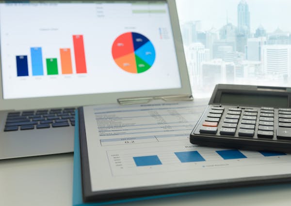 Financial planning accounting concept. Calculator on business and financial report on desk of entrepreneur. istock