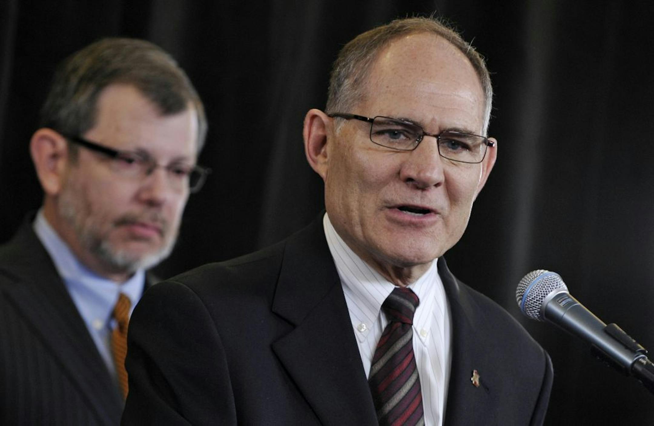 University of Minnesota president Eric Kaler, left, listens as Joel Maturi, who spent a decade serving the Gophers, addresses the media during news conference announcing his retirement.