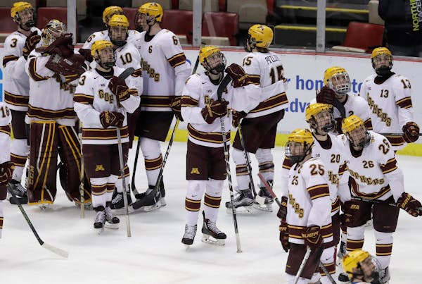 The Minnesota team stands on the ice after a 4-3 loss to Penn State in two overtimes in a semifinal of the Big Ten college hockey tournament, Friday, 