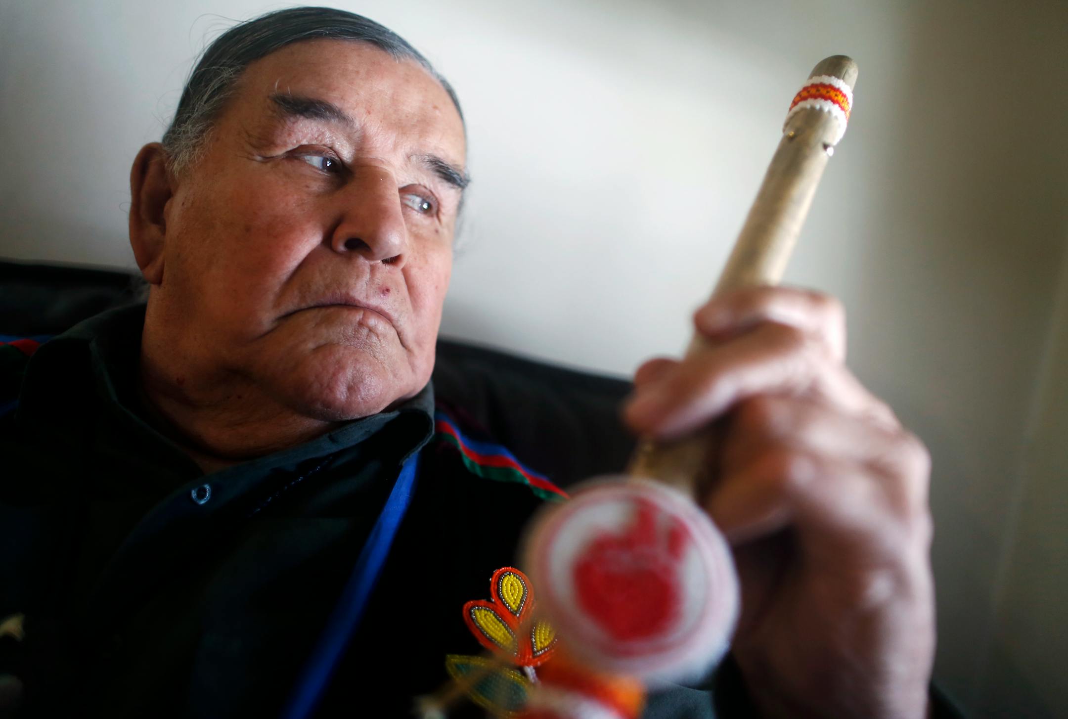 At his home in South Minneapolis, Native American activist Clyde Bellecourt is out of jail after being arrested at a flash mob event at the IDS Center on Monday. He is holding a walking stick with the AIM -- American Indian Movement -- symbol.