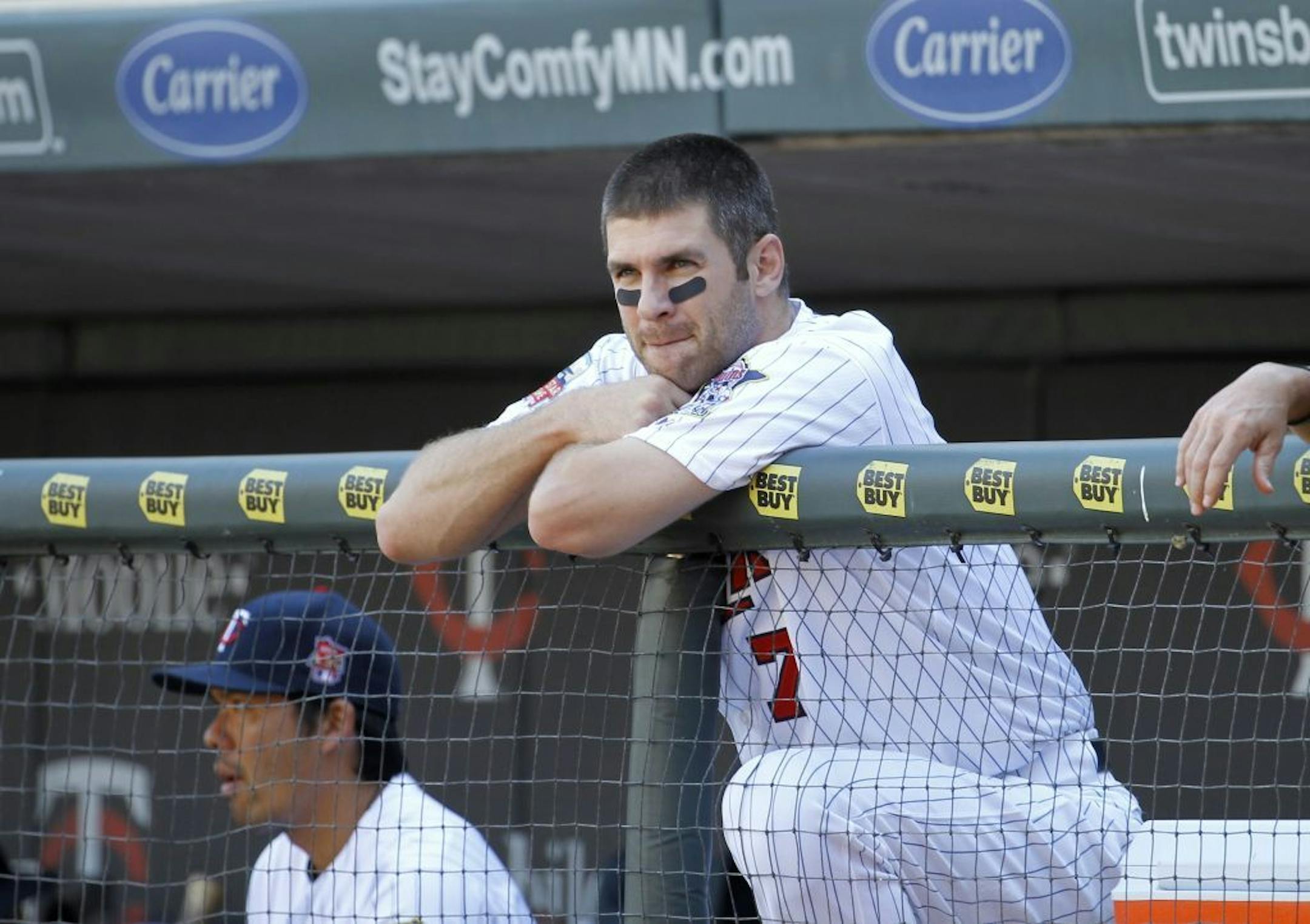 Minnesota Twins' Joe Mauer (7) looks out of the dugout during the sixth inning of a baseball game against the Los Angeles Angels in Minneapolis, Sunday, Sept. 7, 2014. The Angels won 14-4.
