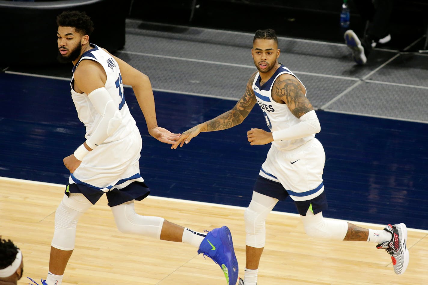 Minnesota Timberwolves center Karl-Anthony Towns (32) and guard D'Angelo Russell (0) celebrate a basket against the Chicago Bulls in the second quarter during an NBA basketball game, Sunday, April 11, 2021, in Minneapolis. (AP Photo/Andy Clayton-King)