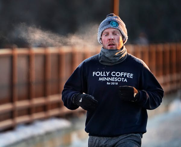 Runner Scott White of Minneapolis braved the frigid cold while crossing the Mississippi River on the Stone Arch Bridge as temps hovered around minus 8