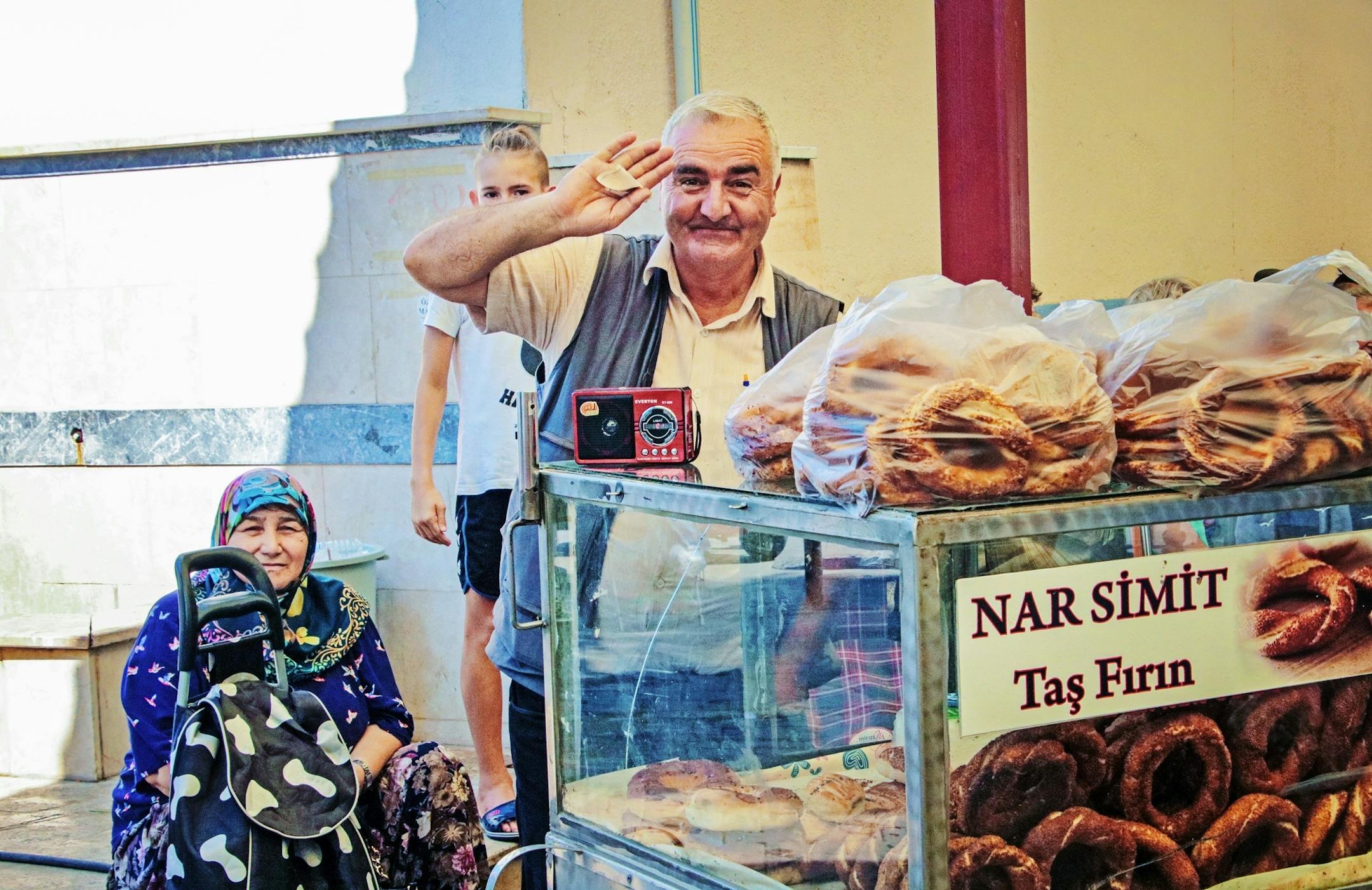 A friendly vendor in Canakkale sells simit bread rings, a favorite street food in Turkey.