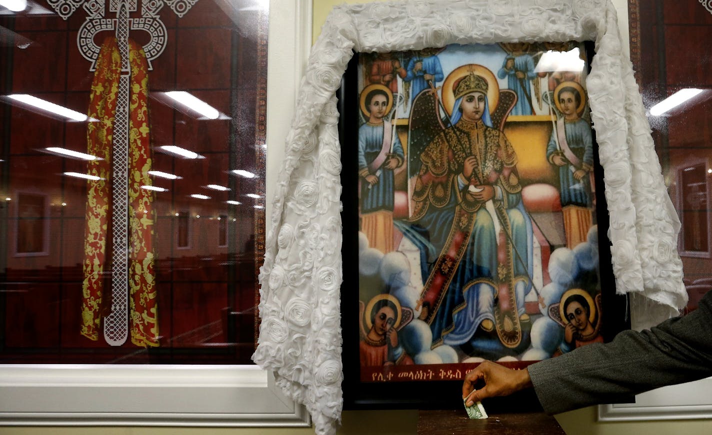 An offering at the Ethiopian Orthodox Tewahedo Church in Minneapolis. A building that once housed an IT supplier on Minnehaha Avenue has been purchased by an Ethiopian group and transformed into a church. ] CARLOS GONZALEZ cgonzalez@startribune.com - August 26, 2015, Minneapolis, MN, A building that once housed an IT supplier on Minnahaha Avenue has been purchased by an Ethiopian group and transformed into a Christian church. Ethiopian Orthodox Tewahedo