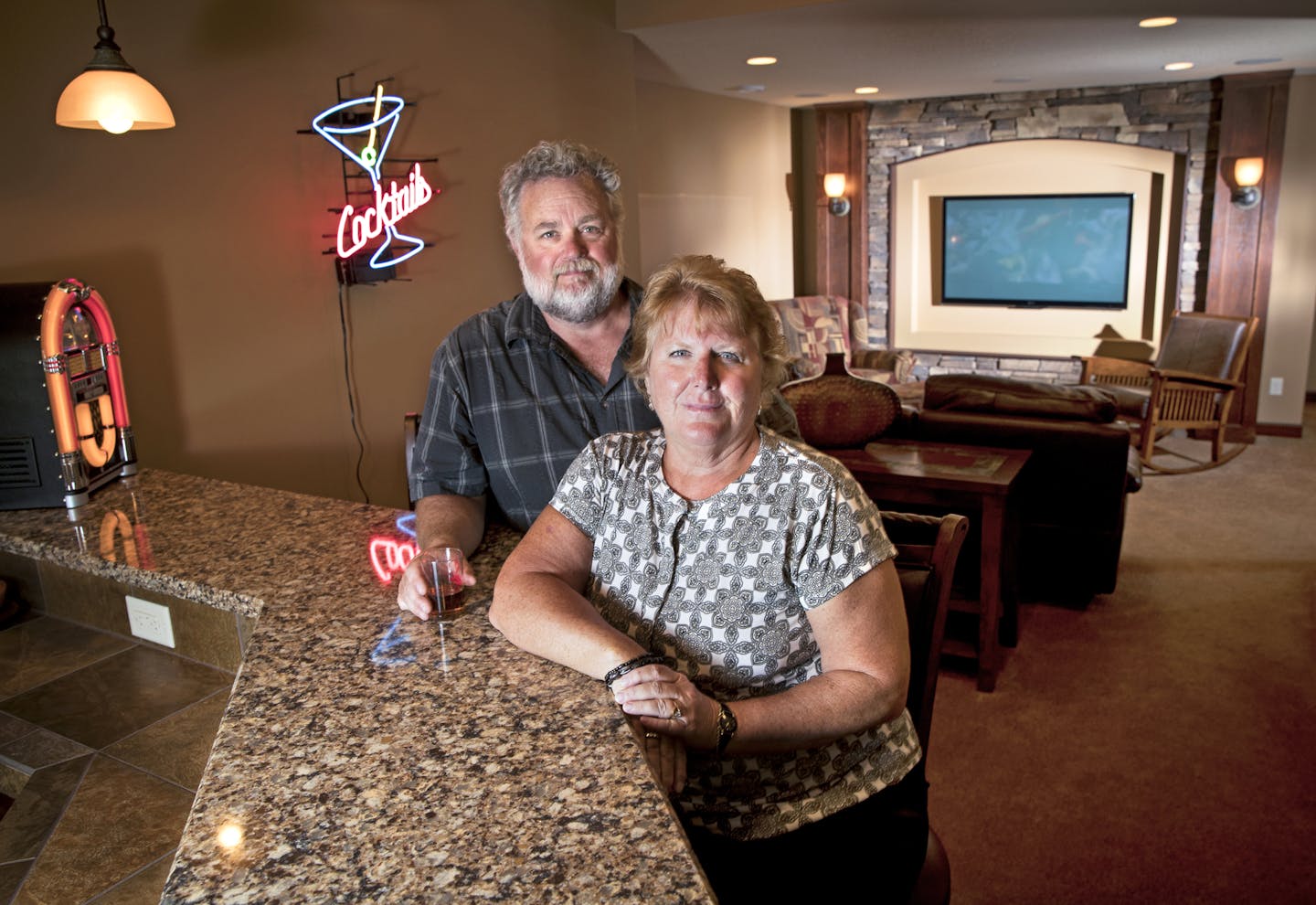 Mary and Mitchell Roach posed for a photograph in their $100k finished basement in their 4000 square foot home on Tuesday, August 2, 2016, in Savage, Minn. The basement includes a bedroom, bathroom, bar, entertainment center and pool table room. ] RENEE JONES SCHNEIDER &#xef; renee.jones@startribune.com After putting their 4,000-plus square-foot house in Savage on the market in April, Mary and Mitchell Roach have done three price reductions and still no offers. Their neighbors were in the same b