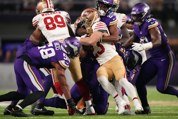 Running back Christian McCaffrey (23) of the 49ers hit a wall of Vikings defenders in the second quarter on Monday night.