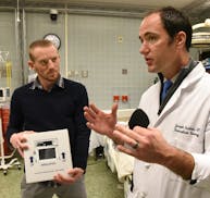 Dr. Joseph Scalea, a transplant surgeon and University of Maryland professor, right, holds a prototype organ monitoring device as he discusses using d