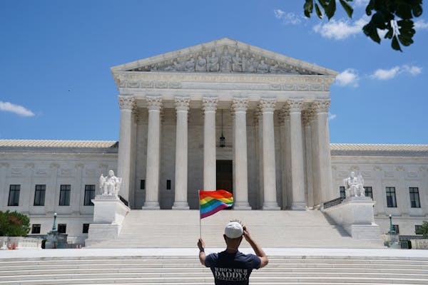 A person waves a rainbow flag in front of the Supreme Court in Washington, on June 15, 2020. 