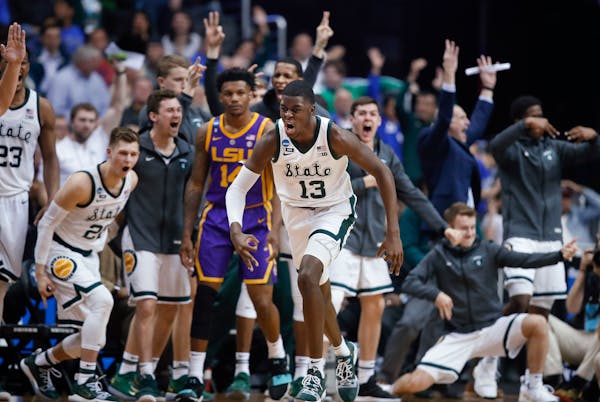 Michigan State forward Gabe Brown (13) and teammates react after he scored against LSU guard Marlon Taylor (14) during the second half