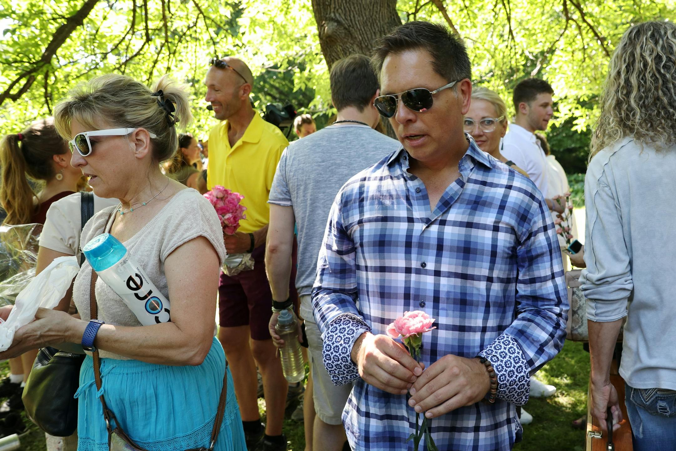 Don Damond looked to throw a flower into the water following a gathering of family and friends to dedicate a bench to Justine Ruszczyk Damond at Minnehaha Creek between 53rd and 54th streets on the one year anniversary of her death.