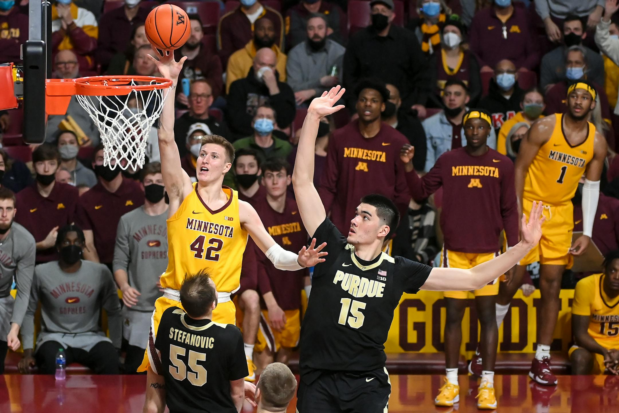 Minnesota Gophers center Treyton Thompson (42) scores a a layup as he was defended by Purdue Boilermakers center Zach Edey (15) and guard Sasha Stefanovic (55) during the second half of an NCAA men's basketball game between Minnesota and Purdue at Williams Arena in Minneapolis, Minn.