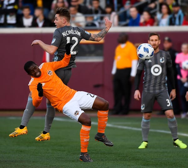 Houston Dynamo midfielder Oscar Garcia (27) and Minnesota United midfielder Sam Nicholson (12) collided while jumping for a header in the first half S