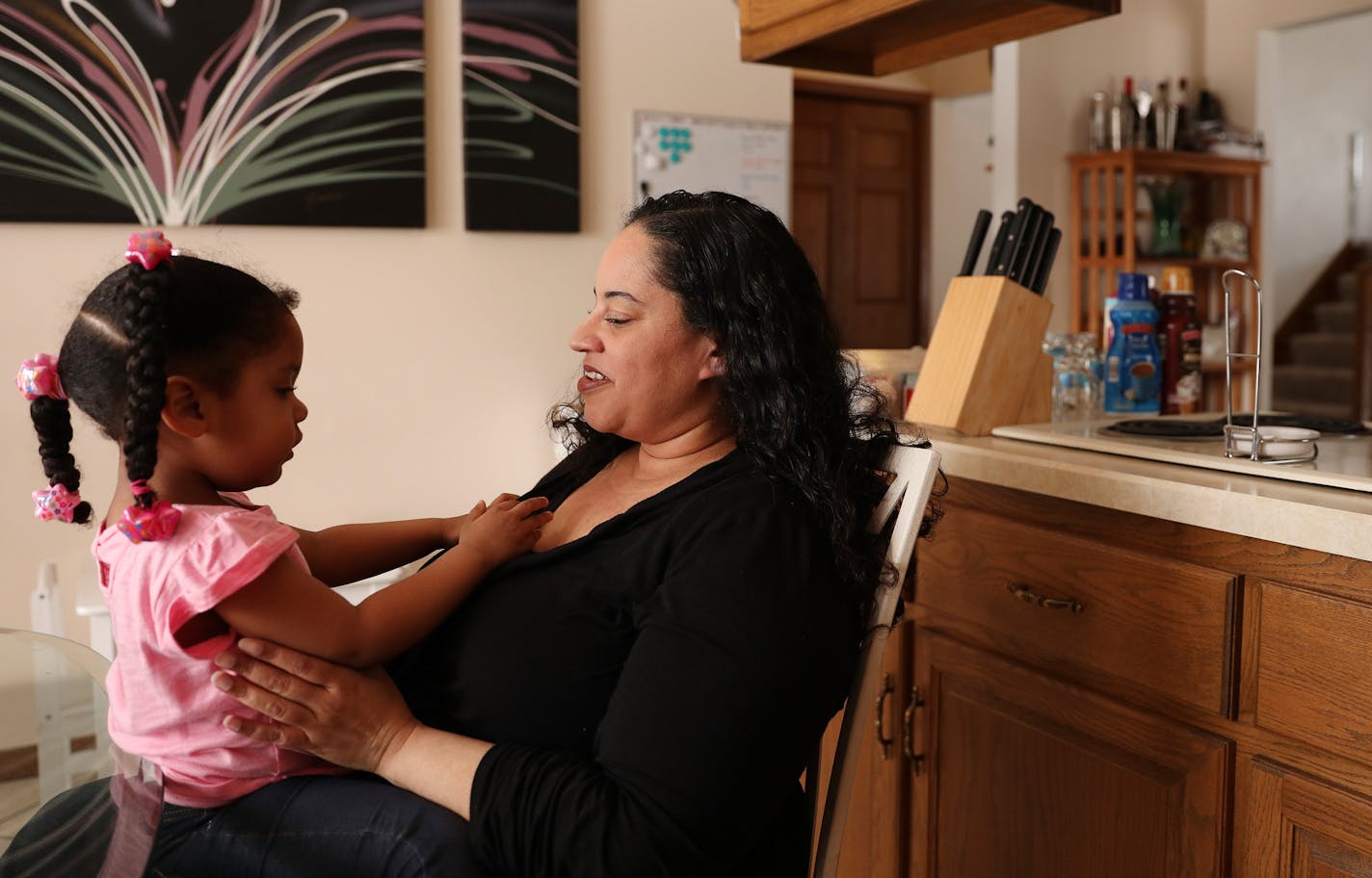 Kera LaSure played with her daughter Thalia Mims, 2, as they sat together in the kitchen of the house LaShure bought through Habitat for Humanity's open market program. ] ANTHONY SOUFFLE &#xef; anthony.souffle@startribune.com Kera LaSure, who brought a home through Habitat for Humanity's open market program, did chores around her home Thursday, April 5, 2018 in Maplewood, Minn. The program allows pre-approved Habitat buyers to search for a home on the open market, usually a modest fixer upper in