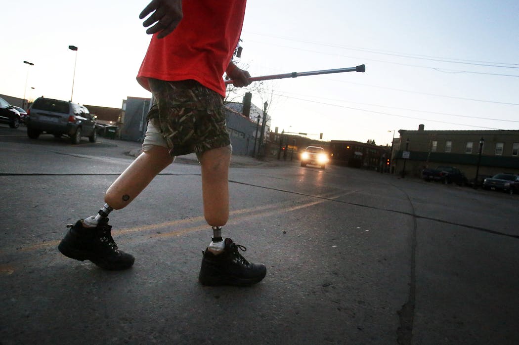 Gerald Pollard uses prosthetic limbs and used an old golf club to steady himself.