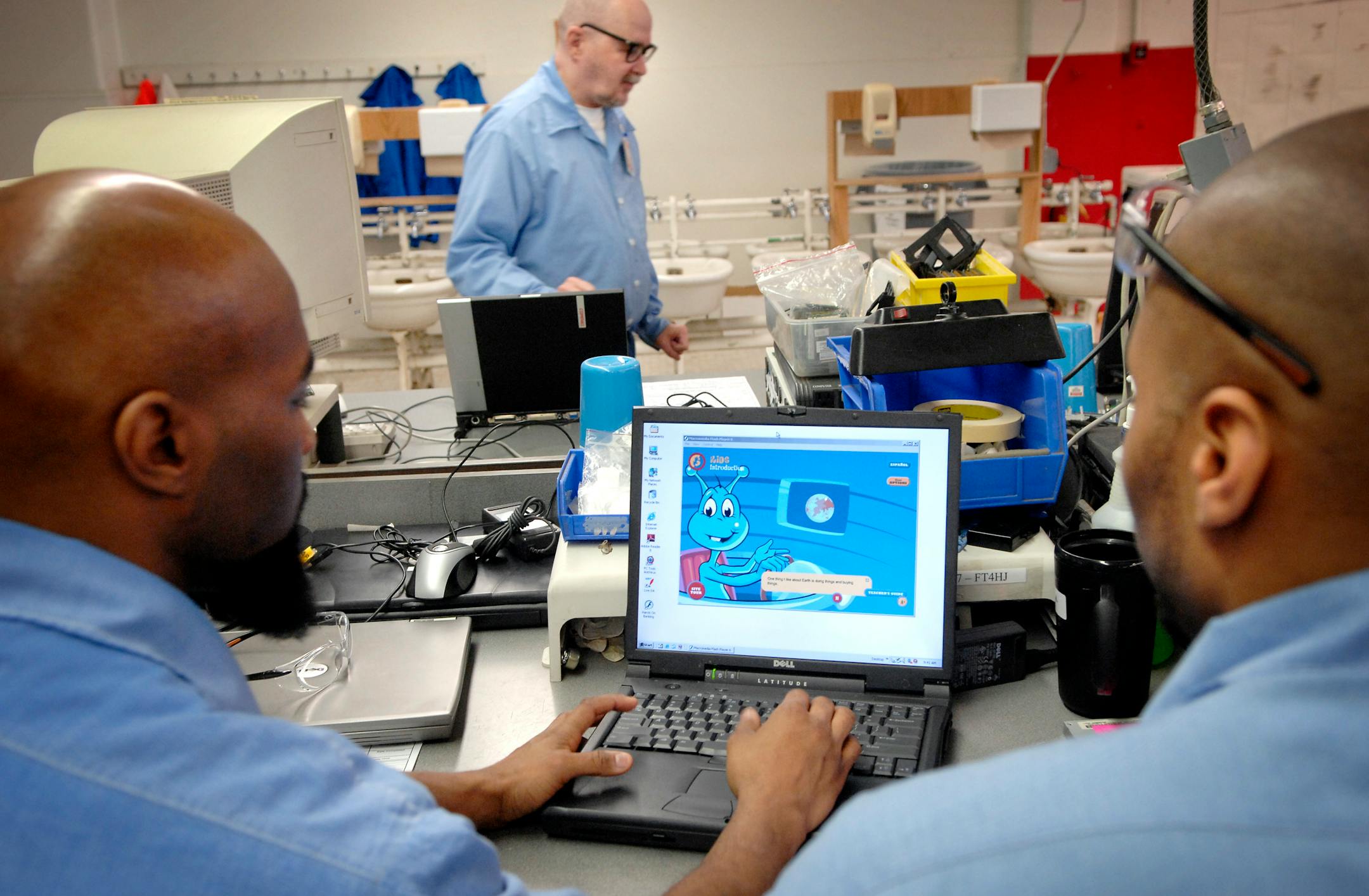 Joseph Young, left, and Adrian Keys, right, loaded educational software into a Dell computer while Ronald Nelson worked on more laptops that will be sent to a school as part of the Minnesota Computers for Schools program at the Stillwater prison.