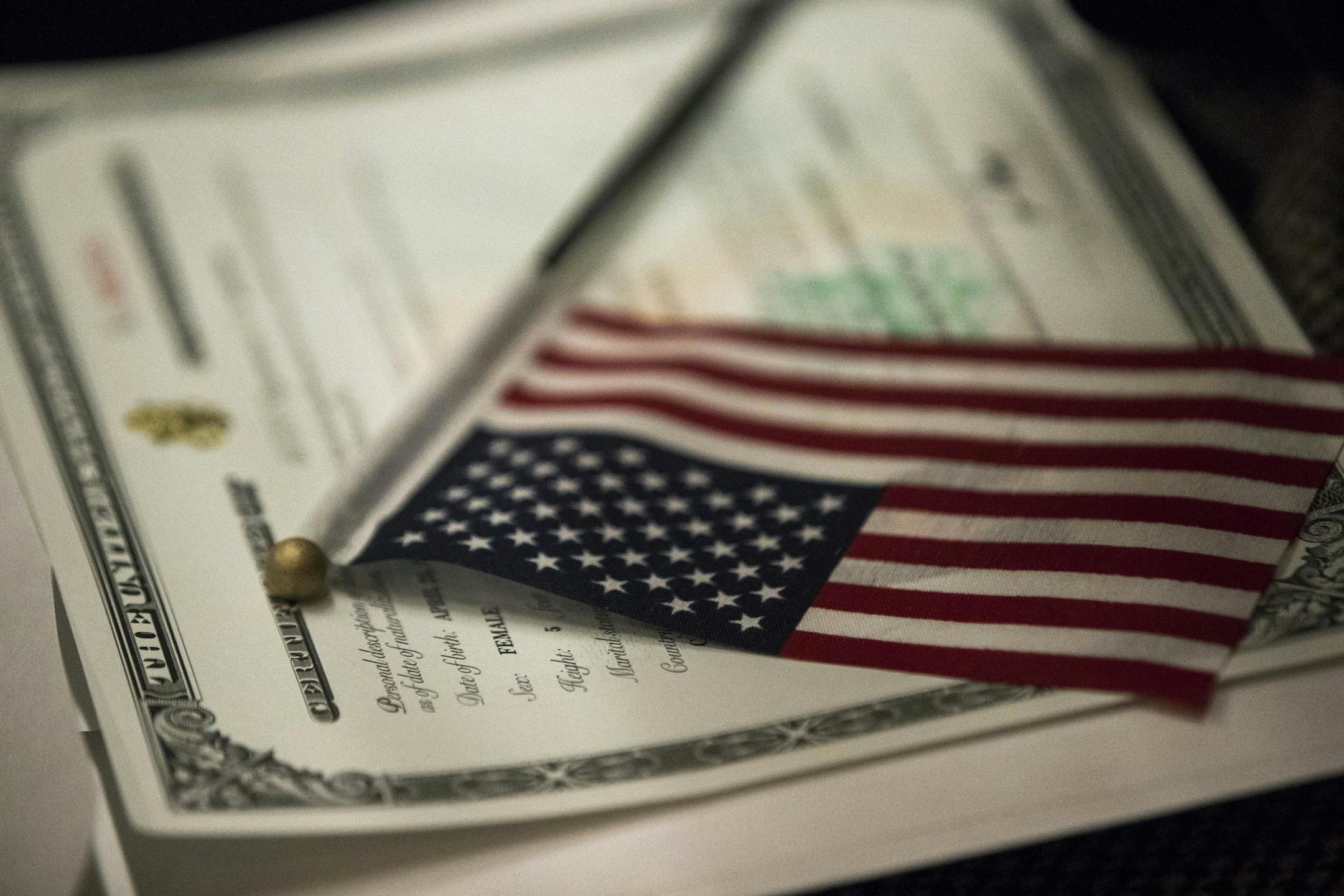 An American flag rests on a Certificate of Citizenship during a naturalization ceremony at the Lower East Side Tenement Museum, Tuesday, Nov. 15, 2016, in New York. (AP Photo/Mary Altaffer)