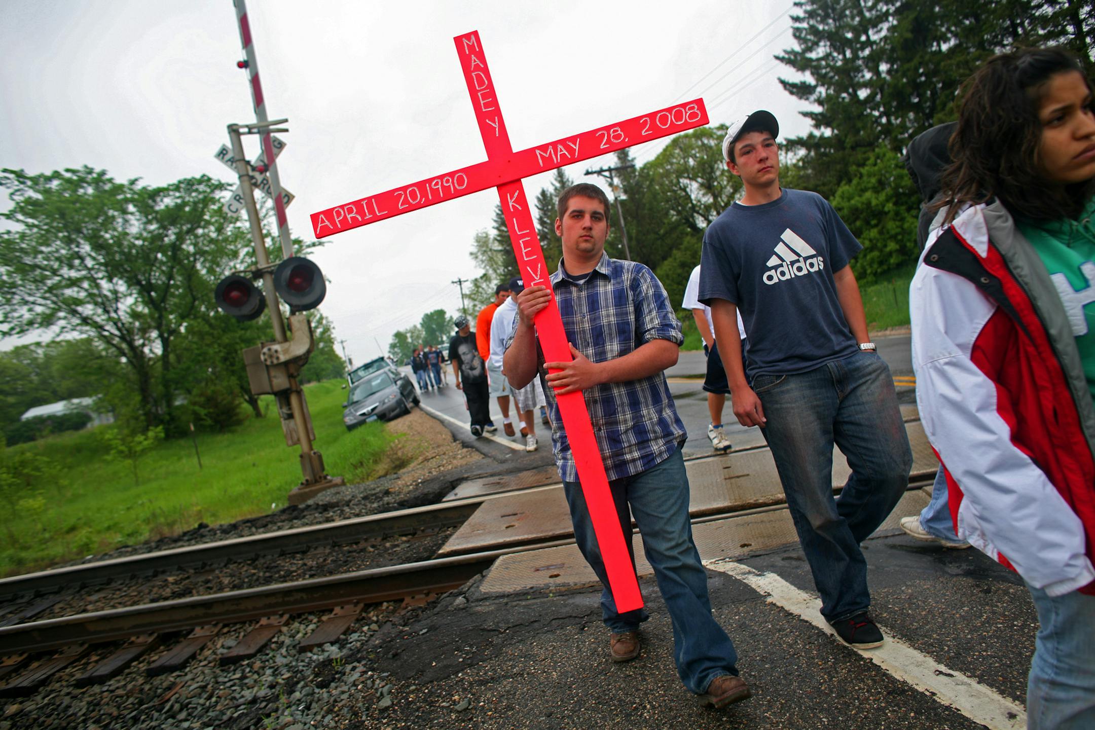 Michael Sawatzke carried a cross he and other Howard Lake-Waverly-Winsted High School students made Thursday to honor senior Madeysen Kleve, who died in a car crash Wednesday night near Annandale. Two classmates in the car were critically injured.