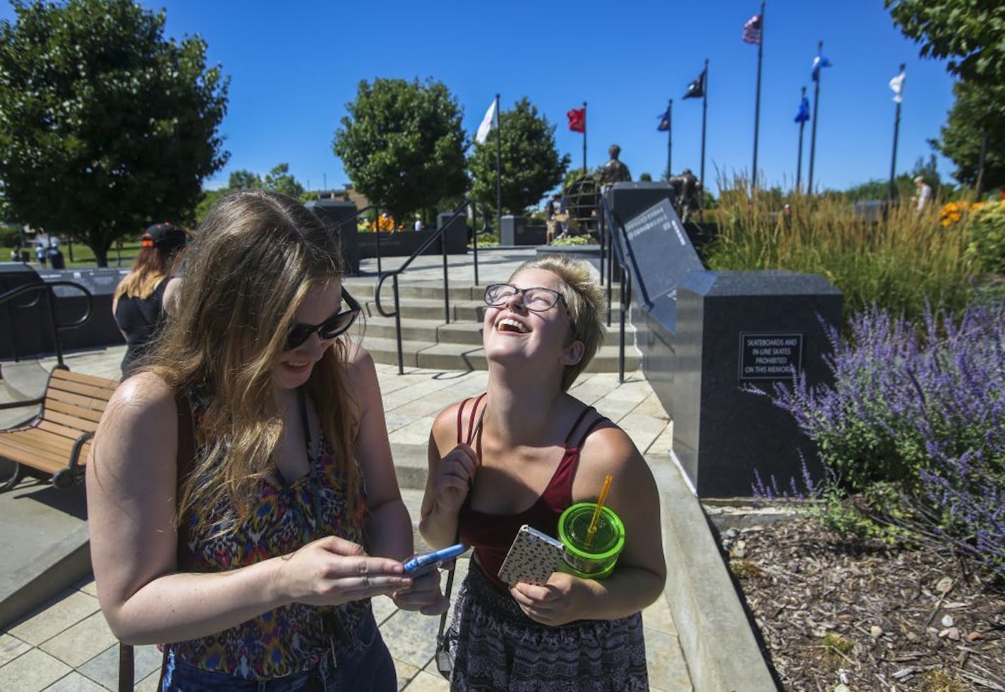 Lexi Reed, left, and Madison Lang share a laugh outside the Veterans Memorial.