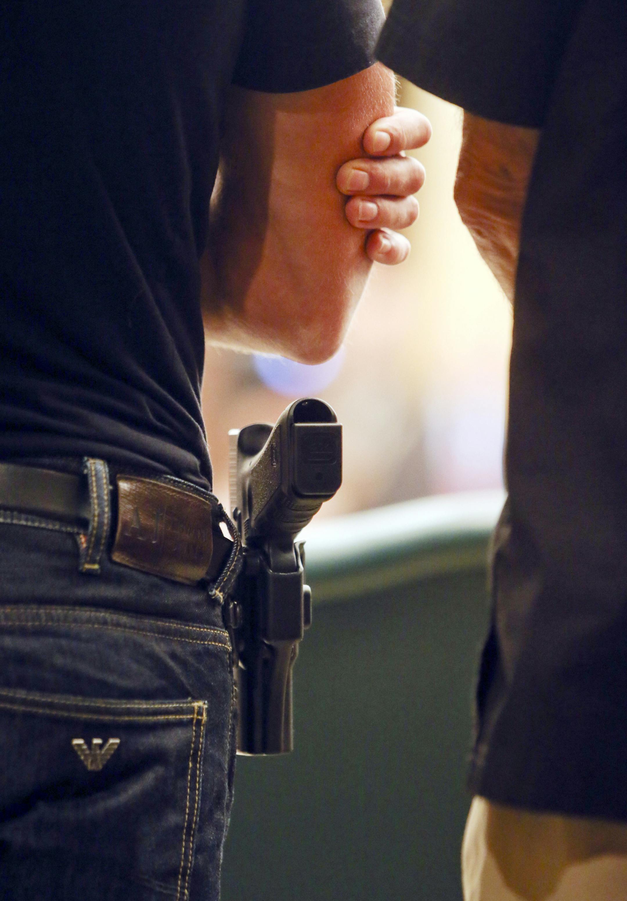 Chris Kranz, left, who said he had a gun permit, openly carried his Glock handgun during the public hearing at the Capitol Tuesday, Aug. 20, 2013. Kranz said it was his 'God given right" to carry a firearm to protect himself, adding that he had been assaulted at age 19 and nearly killed.](DAVID JOLES/STARTRIBUNE) djoles@startribune.com During the second day of hearings on gun-carrying at the Capitol, comments from public were heard with both sides of the issue weighing in Tuesday, Aug. 20, 2013,