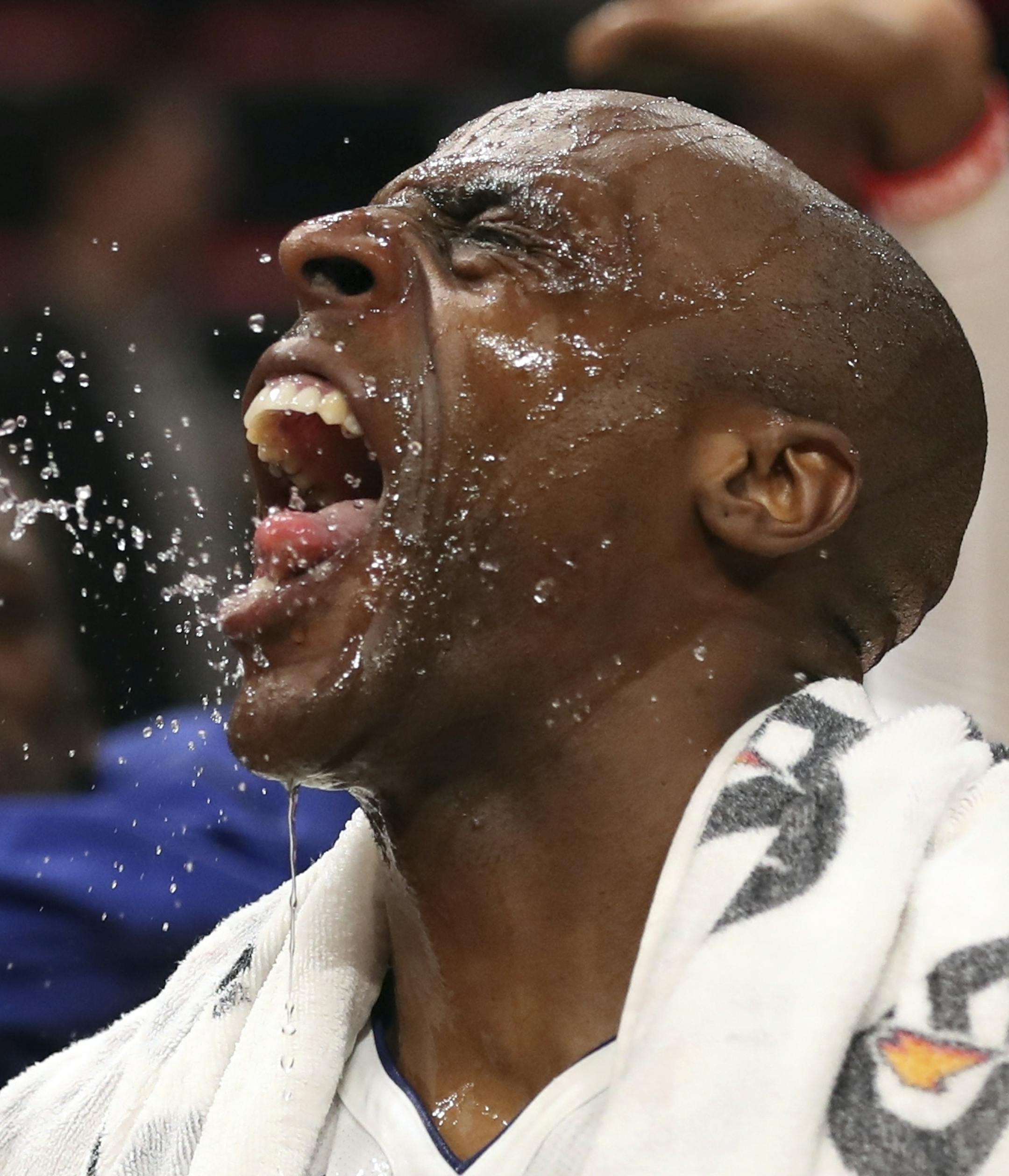 Detroit Pistons center Andre Drummond squirts water into teammate forward Anthony Tolliver as guard Reggie Jackson reacts in the background as Tolliver is interviewed after the second half of an NBA basketball game against the Chicago Bulls, Saturday, March 24, 2018, in Detroit. (AP Photo/Carlos Osorio) ORG XMIT: MICO108