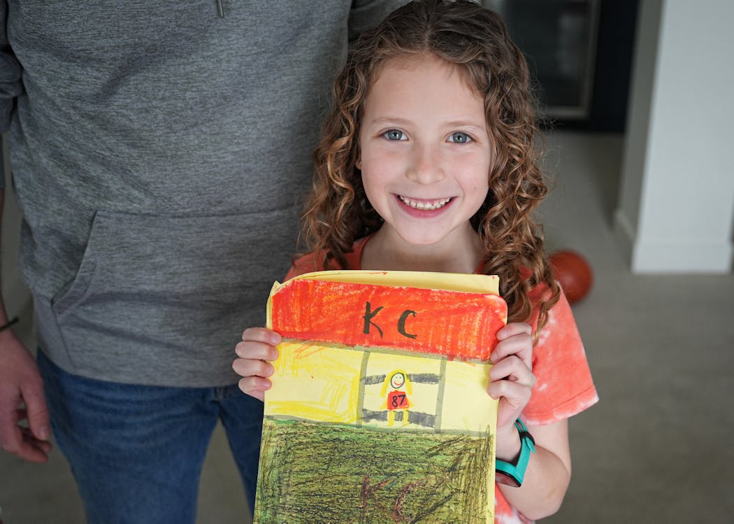 Rory Hodges shows the book she drew of Taylor Swift watching a Kansas City Chiefs football game.
