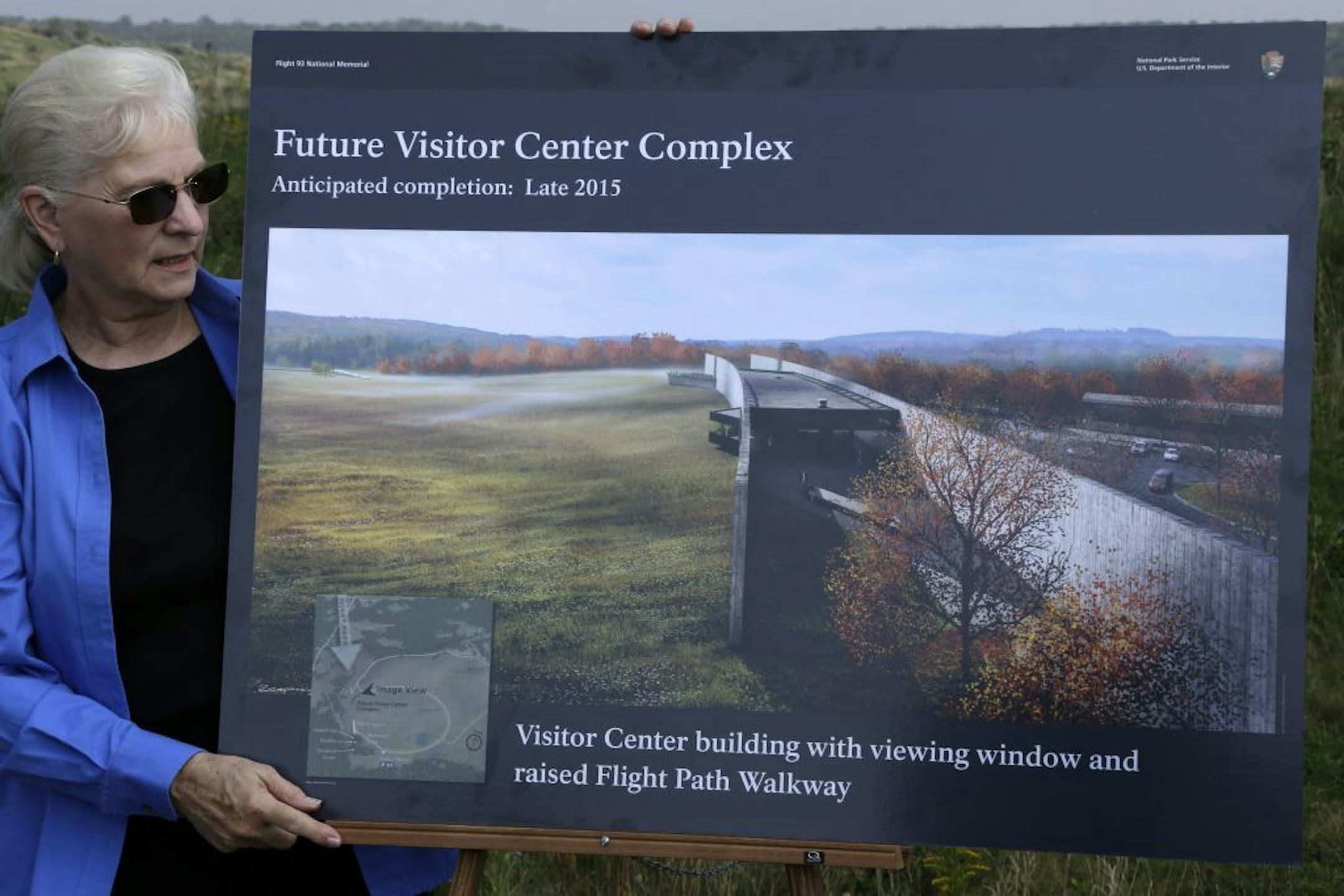 Friends of Flight 93 volunteer ambassador Charlotte Jones holds an artist's rendering of the 450-foot-long Flight 93 National Memorial visitor center complex before a ground breaking ceremony on Tuesday, September 10, 2013, in Shanksville, Pa.
