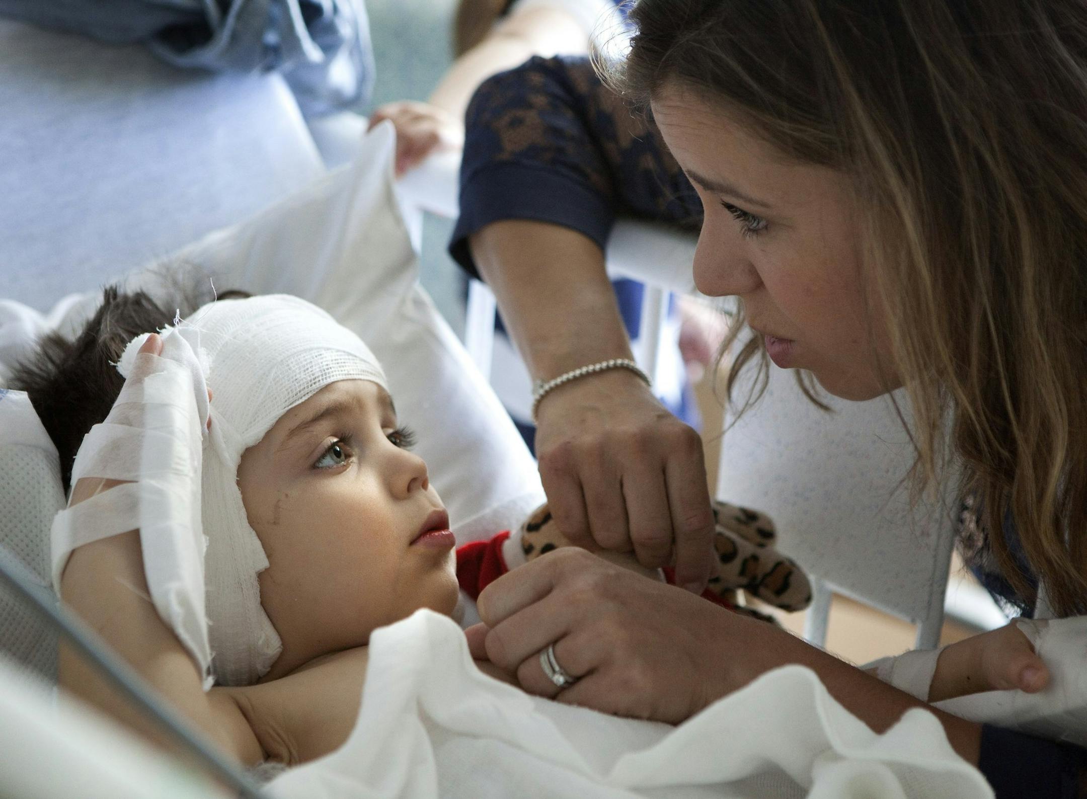 Sophie Gareau, right, looks in on her son Auguste Majkowski during a visit as the three-year-old recovers in his crib at Children's Hospital Los Angeles on May 11, 2014. Surgeons implanted an auditory device into Auguste's brain stem. (Brian van der Brug/Los Angeles Times/MCT)