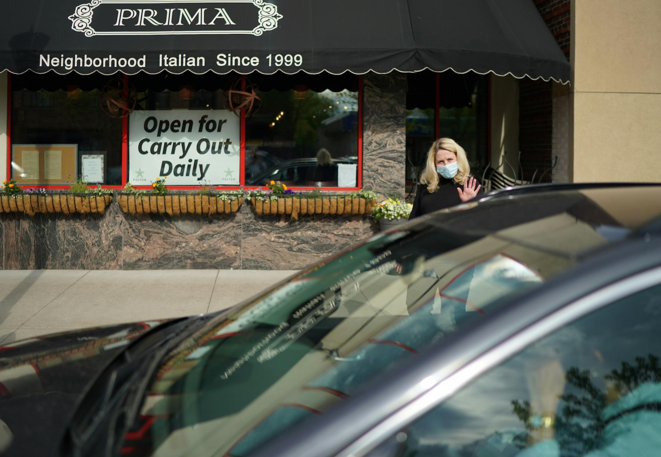 Jennifer King, owner of Prima, kept an eye on the food delivery parking spots in front of her restaurant on Lyndale Ave and she delivered their orders. In between deliveries, she checked for incoming orders on her phone.