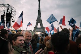 Supporters of French President Emmanuel Macron celebrate on the Champ de Mars in Paris on April 24 after hearing that Macron had won re-election.