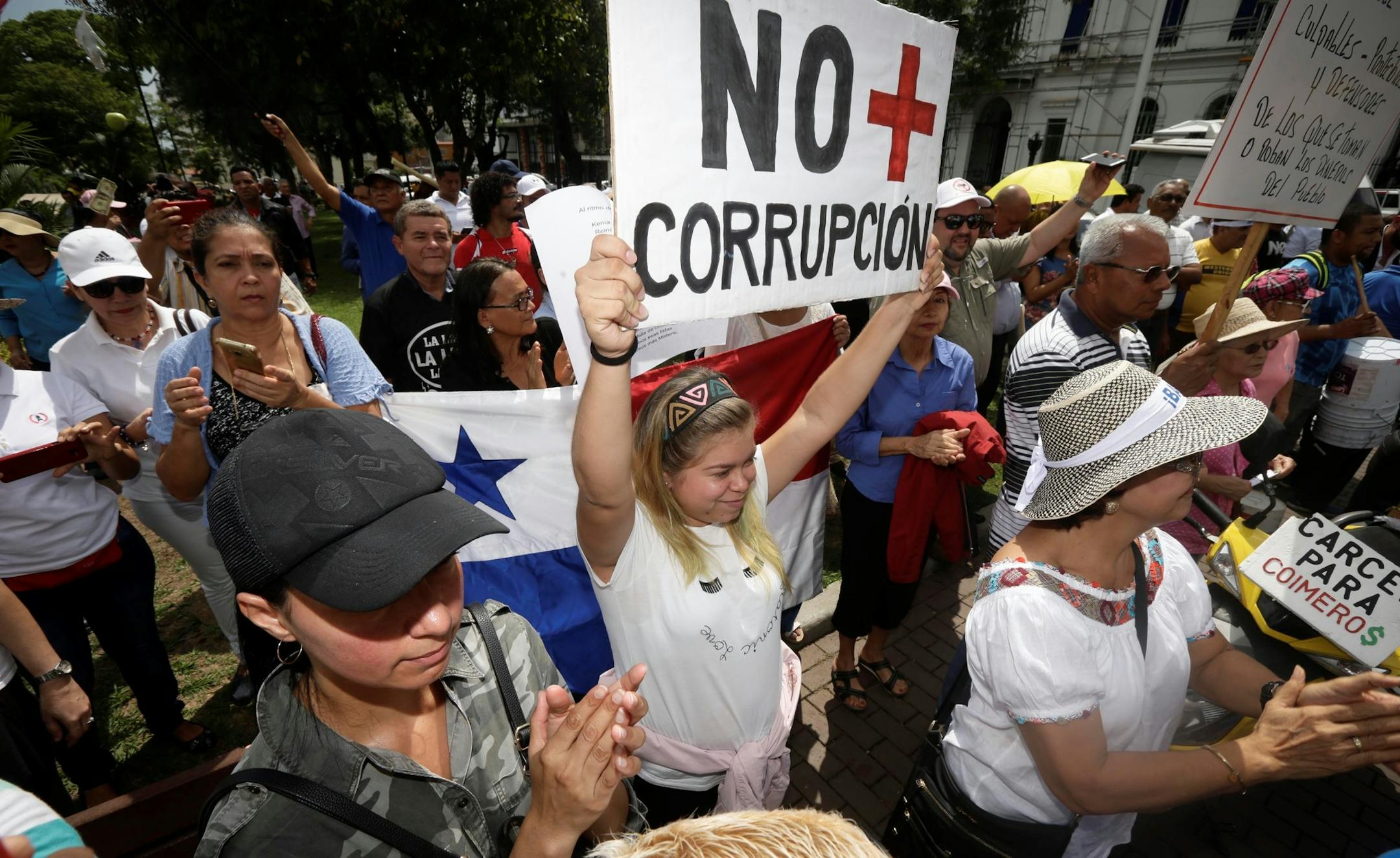 A protester holds up a sign that reads in Spanish "No more corruption" during a demonstration against corruption outside the attorney general's office in Panama City, Tuesday, Jan. 23, 2018. Demonstrators are protesting corruption tied to the Brazilian construction company Odebrecht, involved in Latin America's biggest corruption scandal. (AP Photo/Arnulfo Franco) ORG XMIT: PAN101