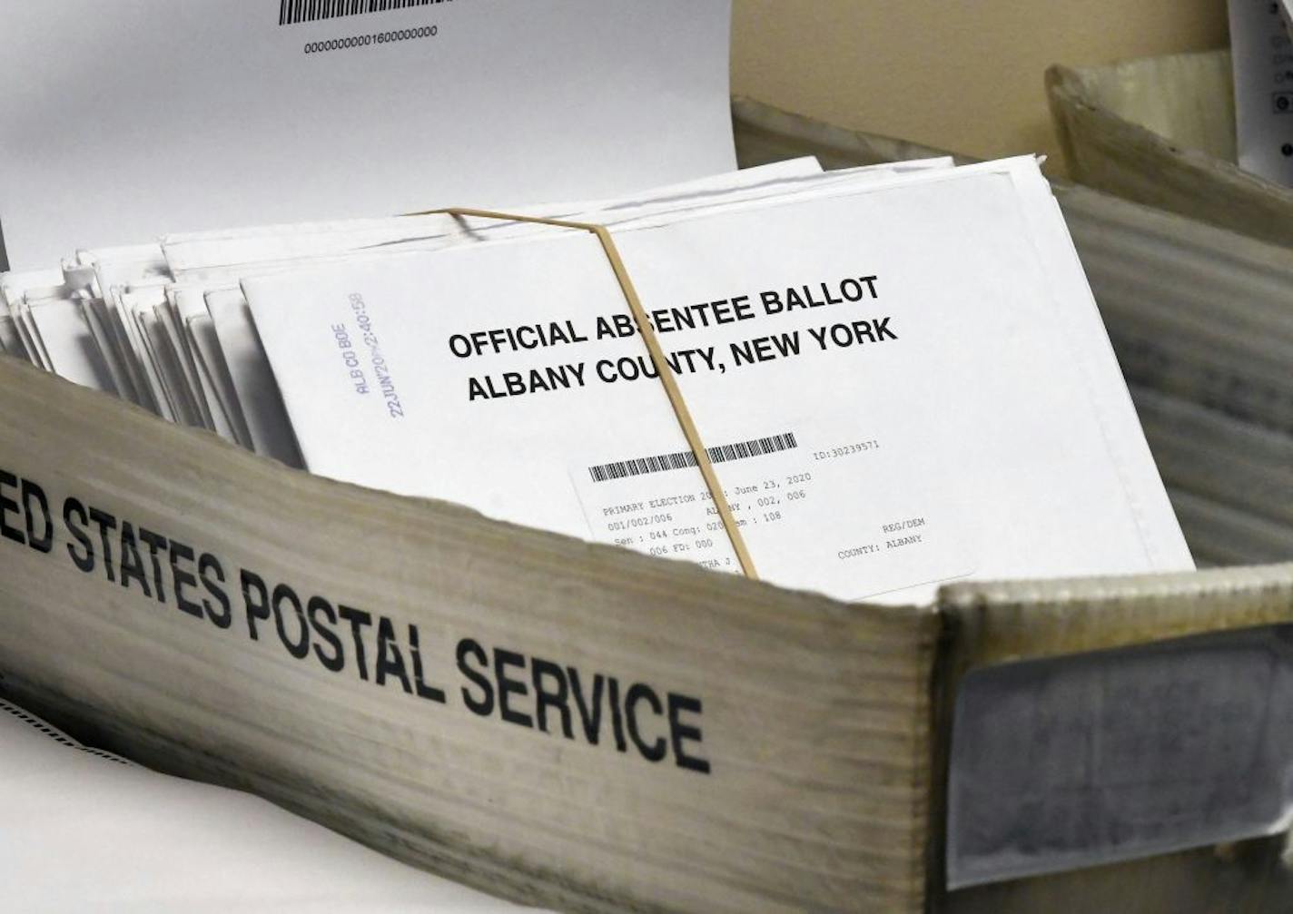 In this June 30, 2020, photo, a box of absentee ballots wait to be counted at the Albany County Board of Elections in Albany, N.Y. A New York federal judge ordered the U.S. Postal Service to live up to its responsibilities to timely process election mail. The Monday, Sept. 21 written decision by Judge Victor Marrero came after several individuals including candidates for public office sued.