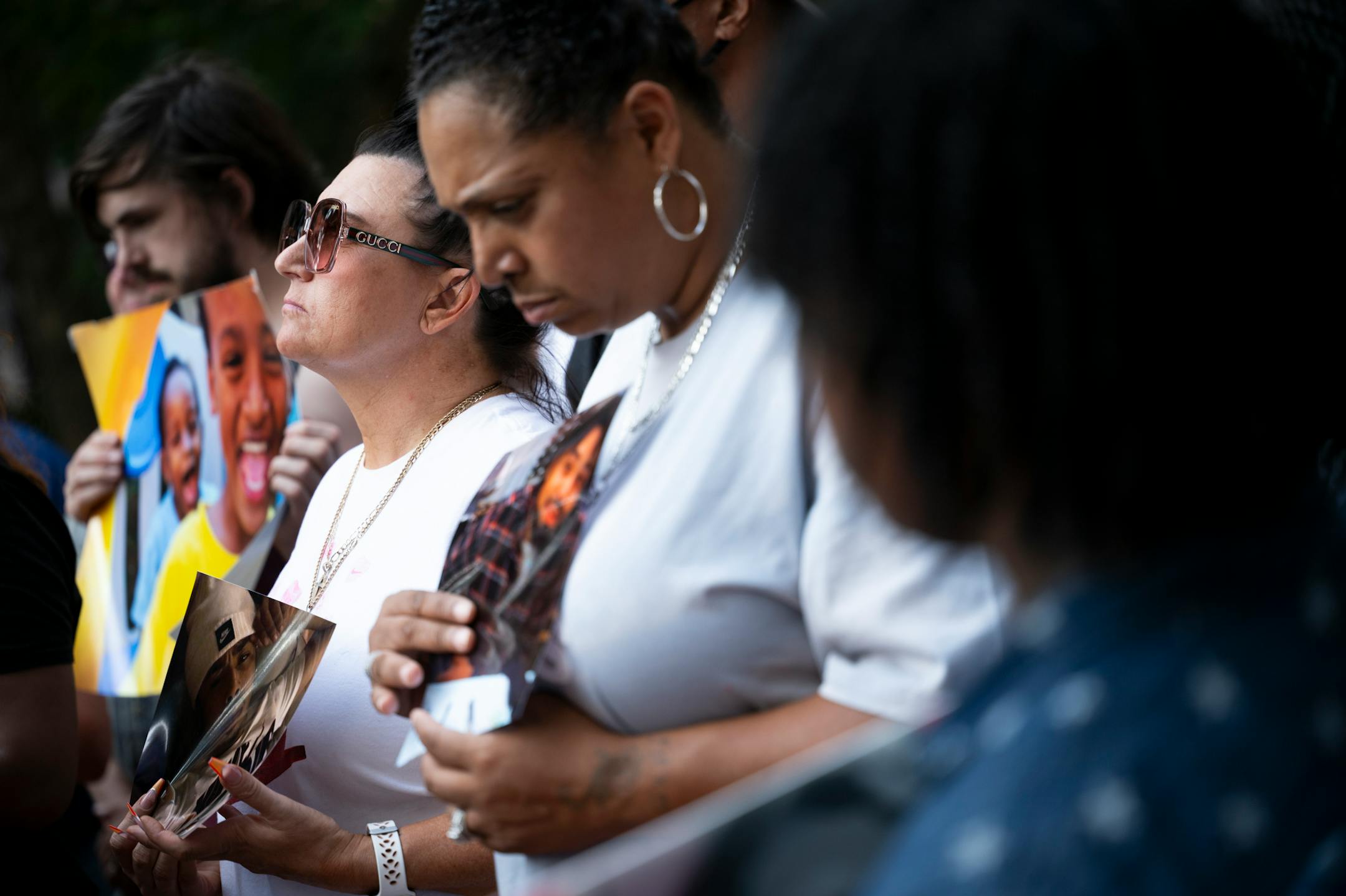 Jolene Anderson, left of center, and close friend Monique Johnson hold photos of Monique's son, Howard Johnson during a rally outside the Hennepin County Government Center Friday, June 16, 2023, in Minneapolis, Minn. Johnson, a 24-year old black man, was killed by St. Paul Police in 2022. The US Department of Justice released the findings in its sweeping investigation into the Minneapolis Police Department finding it routinely engaged in a pattern of racist and abusive behavior.