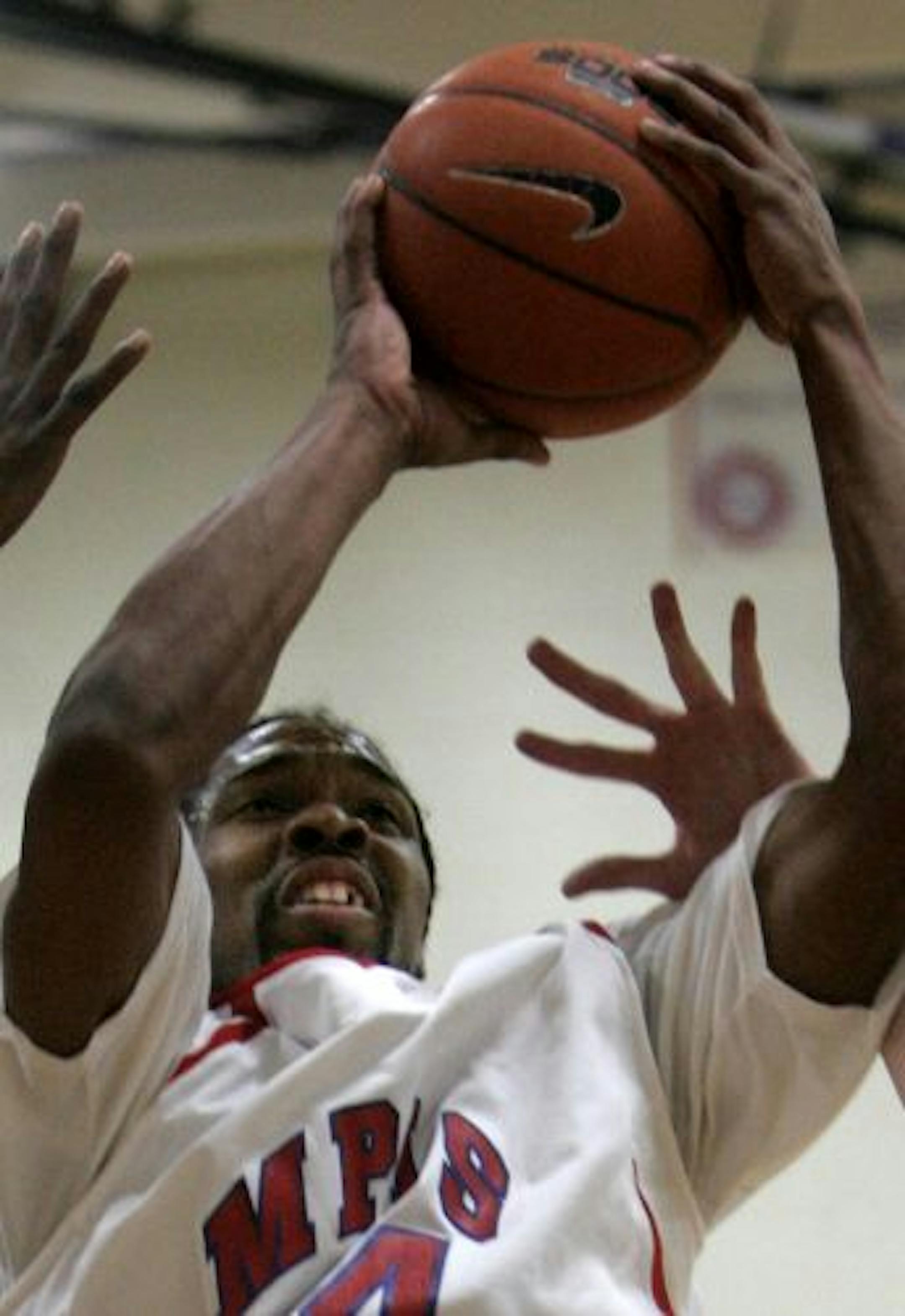 MCTC hoops star Cortez Wallace puts up a jumpshot while being double covered during MCTC's win over MSCTC Fergus Falls. Wallace didn't play any high school basketball but got his GED, enrolled at MCTC and will likely play NCAA division II baskeball next season.