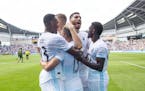 Teammates swarm Minnesota FC midfielder Ethan Finlay (13) after he hit the games only goal on a penalty kick in the 90'+ minute to lift the Loons over