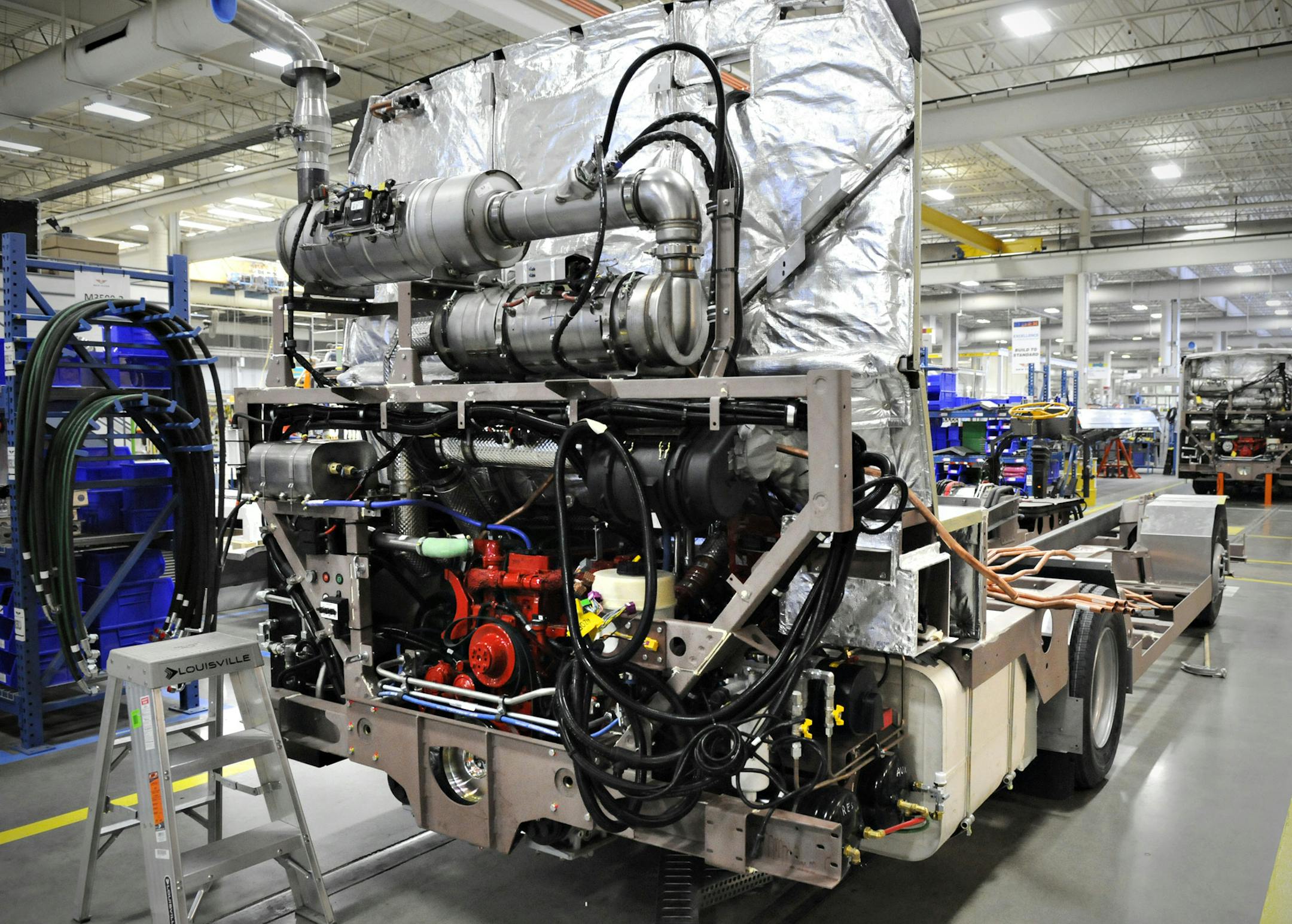 In this Friday, April 4, 2014 photo, the engine and other equipment get installed to the frame of a new MiDi bus at New Flyer Industries St. Cloud, Minn. The MiDi is the company's first collaboration with another company, Alexander Dennis Ltd. of Scotland. (AP Photo/St. Cloud Times, Jason Wachter)