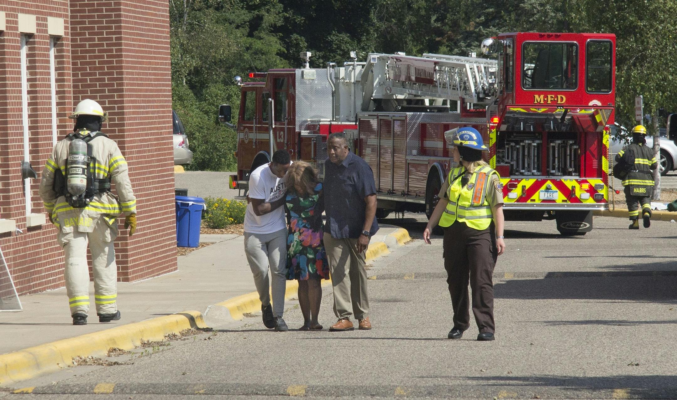 Minnehaha Academy President Donna Harris is helped away from the school shortly after the explosion.