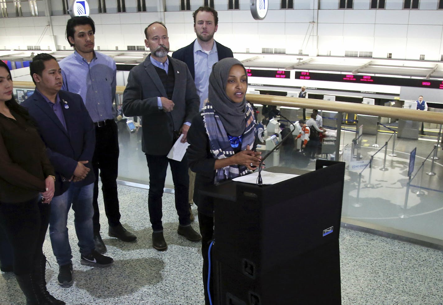 Rep. Ilhan Omar (D-Minn), right, addresses a news conference Tuesday, Jan. 22, 2019 at the Minneapolis-St. Paul International Airport accompanied by constituents behind her affected by the government shutdown, called for an end to the shutdown. (AP Photo/Jim Mone)