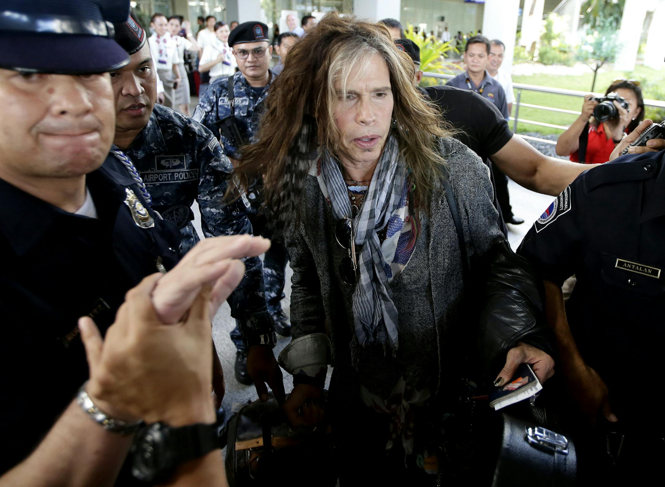 Steven Tyler of the famed Aerosmith rock band is mobbed by reporters as he makes his way to his waiting van upon arrival from Melbourne Sunday May 5, 2013 in Manila, Philippines. Tyler and his entourage are here as part of their band's world tour concert. (AP Photo/Bullit Marquez)