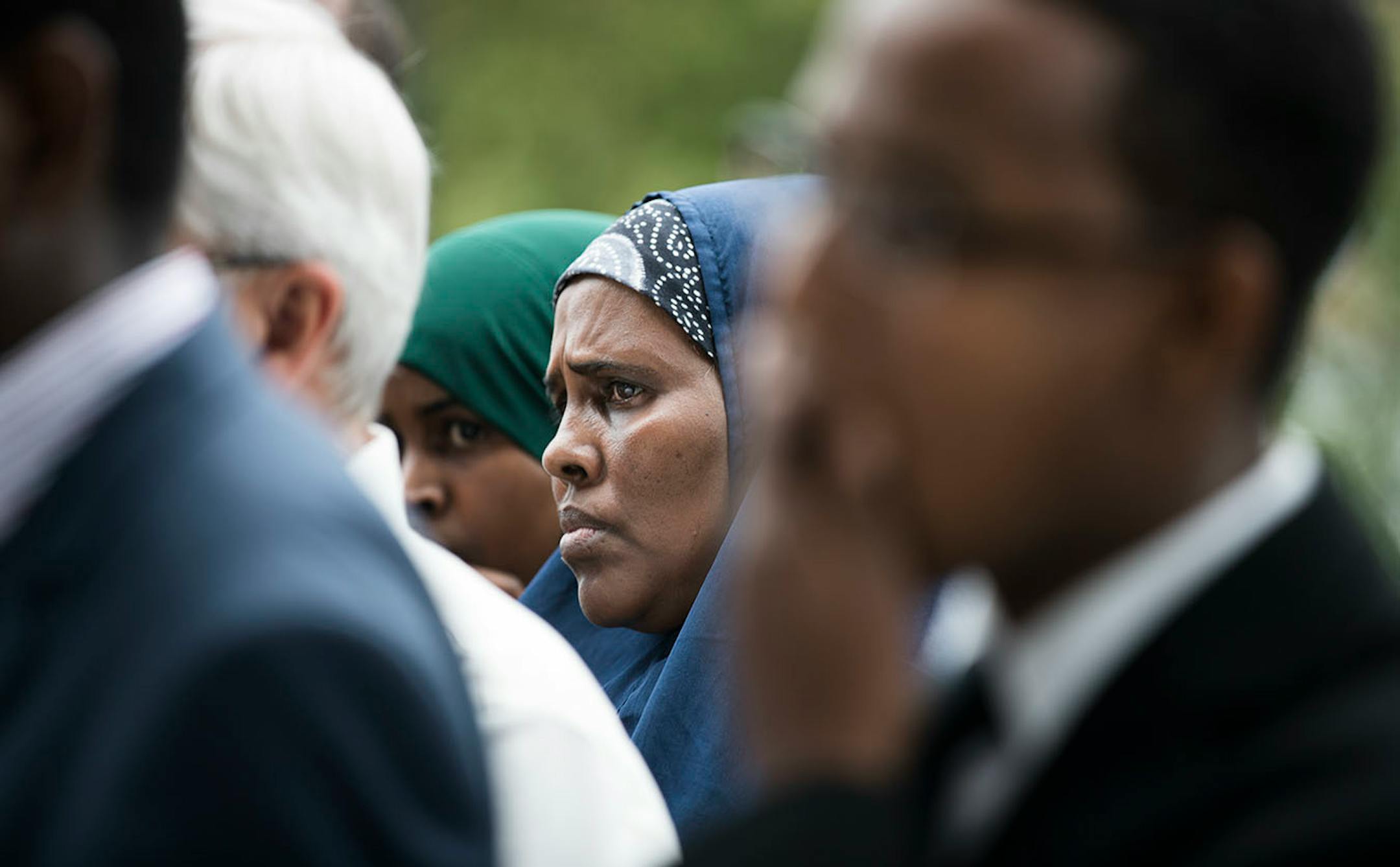 A woman stands in the back during a press conference with the Somali community in St. Cloud.