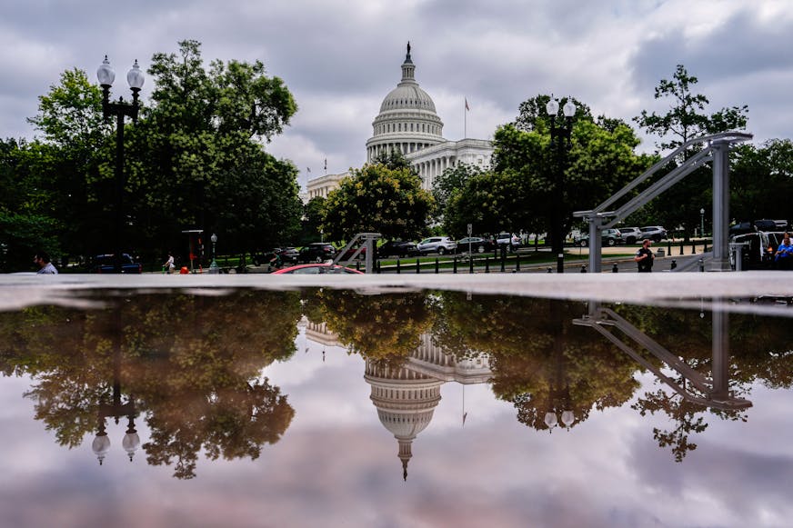 The U.S. Capitol is reflected in a puddle outside of the Rayburn House Office Building on July 16 on Capitol Hill in Washington.