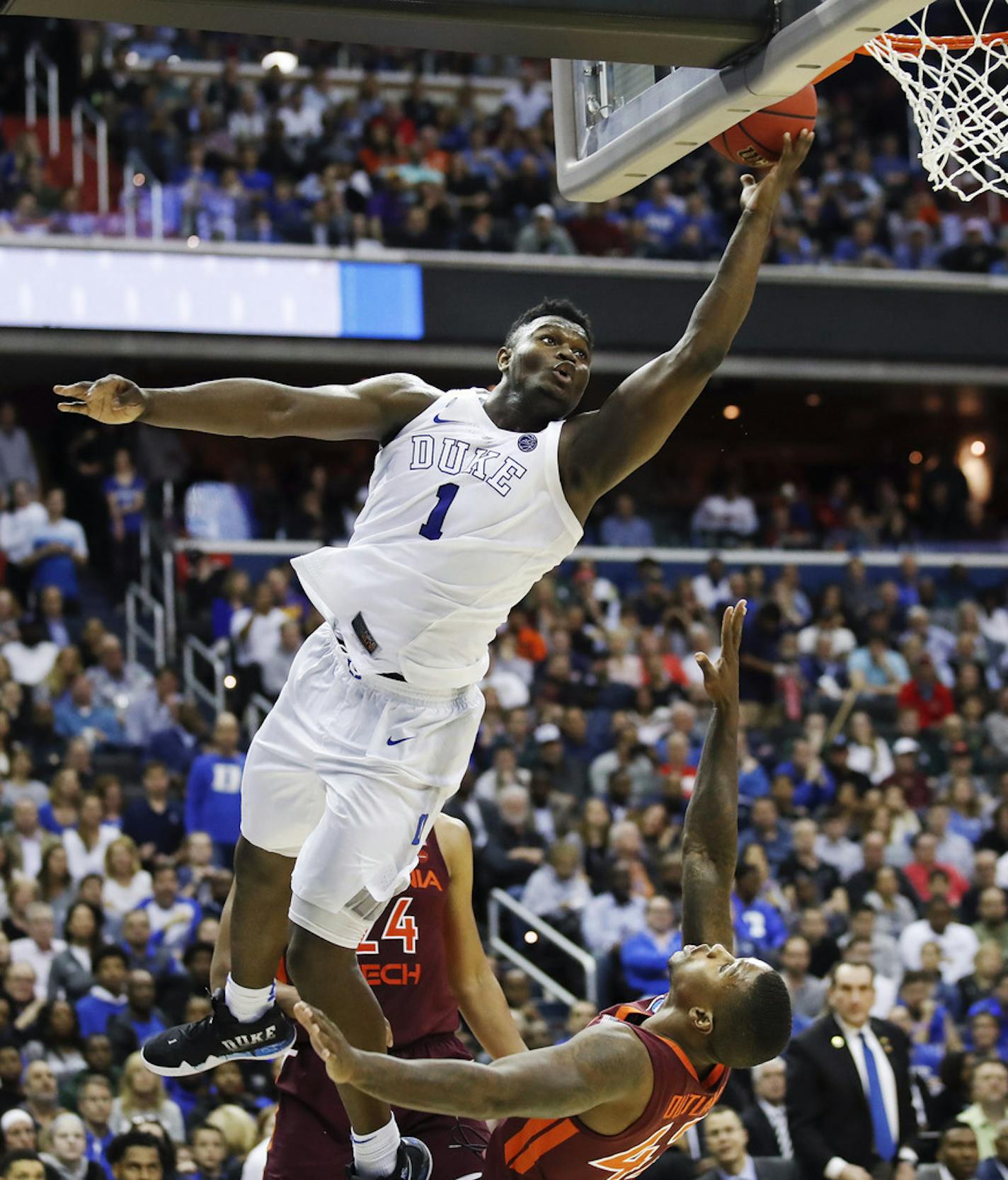 Duke forward Zion Williamson (1) drives to the basket to score on Virginia Tech's guard Ty Outlaw (42) during the second half of an NCAA men's college basketball tournament East Region semifinal in Washington, Friday, March 29, 2019. (AP Photo/Alex Brandon)