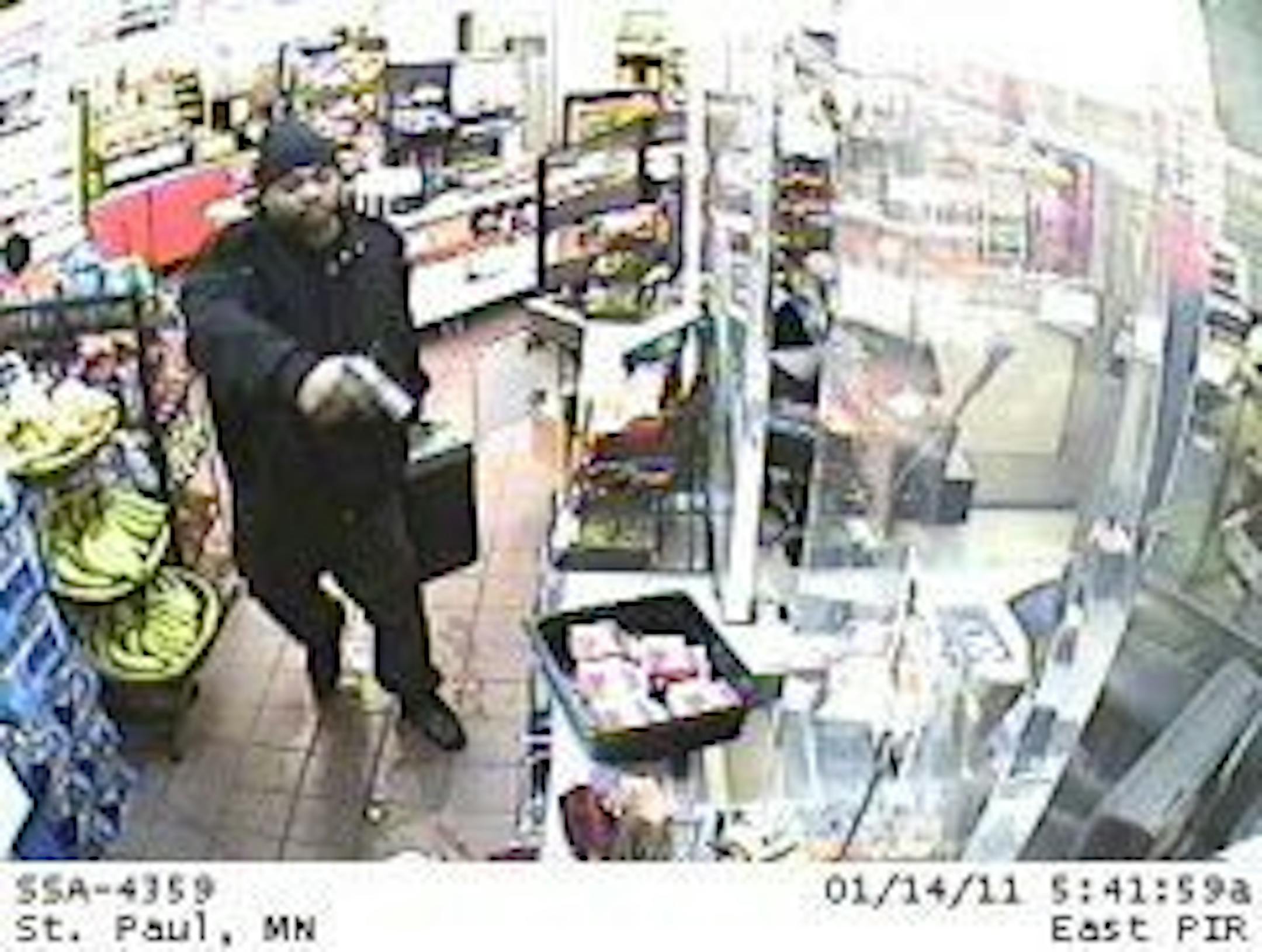 In this screen grab from surveillance video, a gunman is seen confronting an armored truck guard filling an ATM inside a Super America in St. Paul on Jan. 14, 2011. Video provided by the FBI.